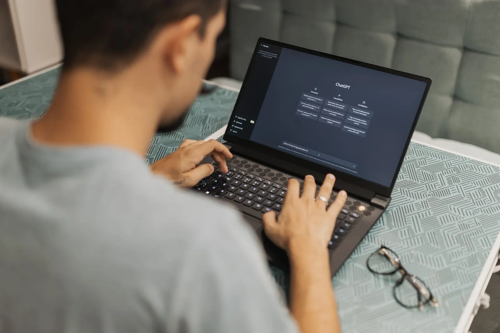 Hombre trabajando con un ordenador portátil que muestra una interfaz de asistente de inteligencia artificial