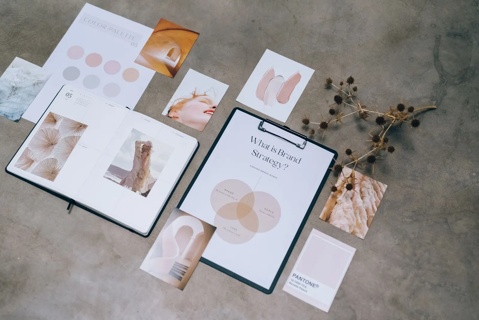 Composición sobre fondo gris con paleta de colores, bocetos y documentos de estrategia de marca