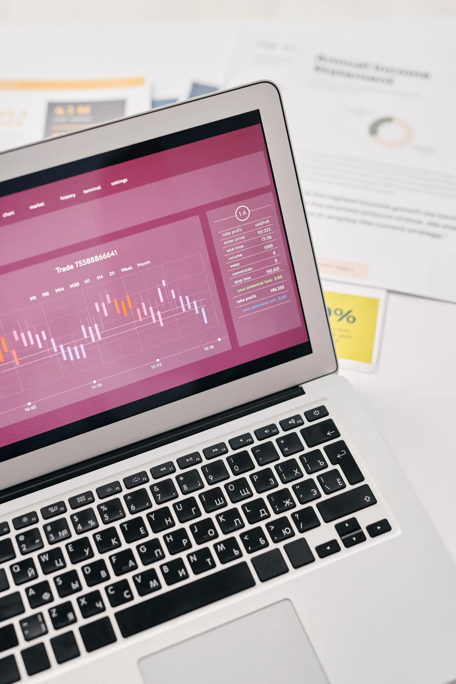 Ordenador portátil mostrando gráficos de datos sobre una mesa con documentos