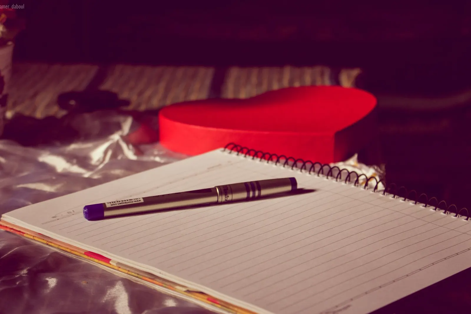 Cuaderno abierto con un bolígrafo morado sobre una mesa con luz cálida